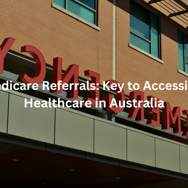 The image shows a large sign on the facade of a building that says "Medicare Referrals: Key to Accessing Healthcare in Australia". The sign has large red lettering against a brick wall background.