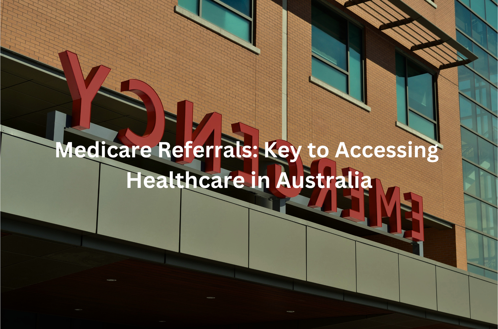 The image shows a large sign on the facade of a building that says "Medicare Referrals: Key to Accessing Healthcare in Australia". The sign has large red lettering against a brick wall background.